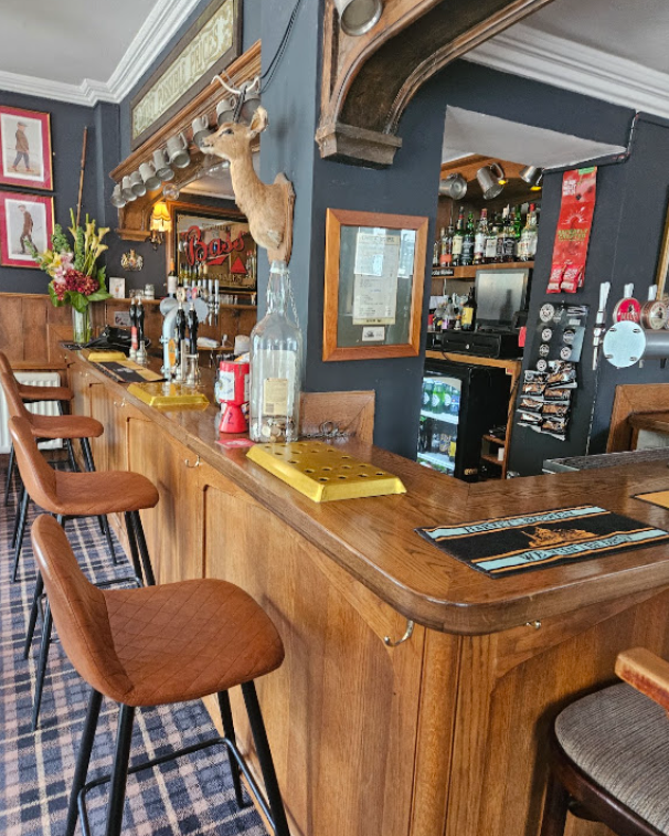 Wooden bar, stools and pub decor inside the Two Doves