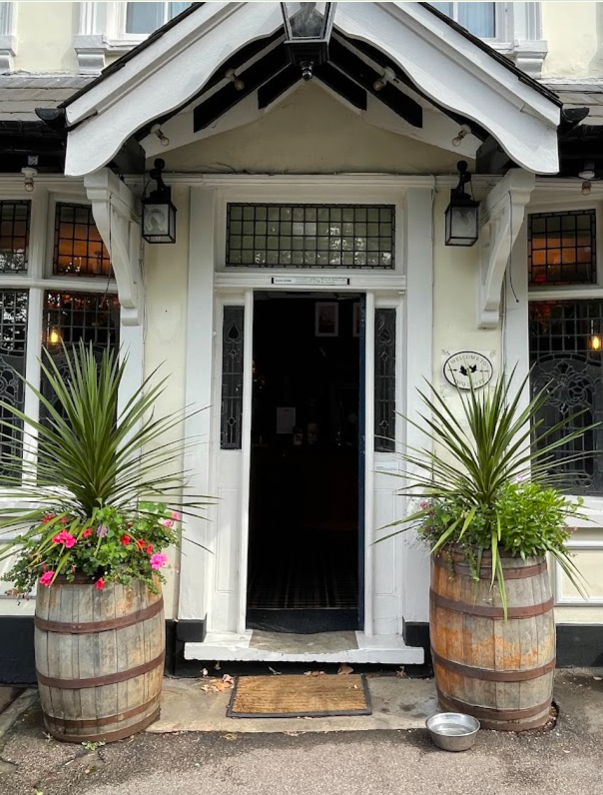 The Two Doves entrance with barrel planters